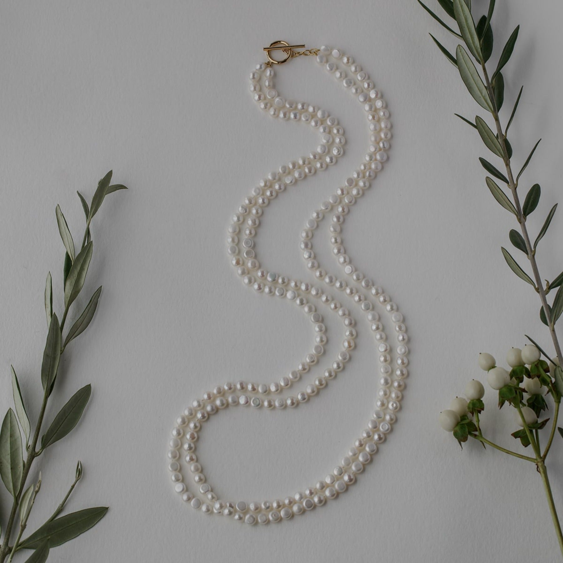 Long opera length button pearl necklace with 14k gold filled toggle clasp.