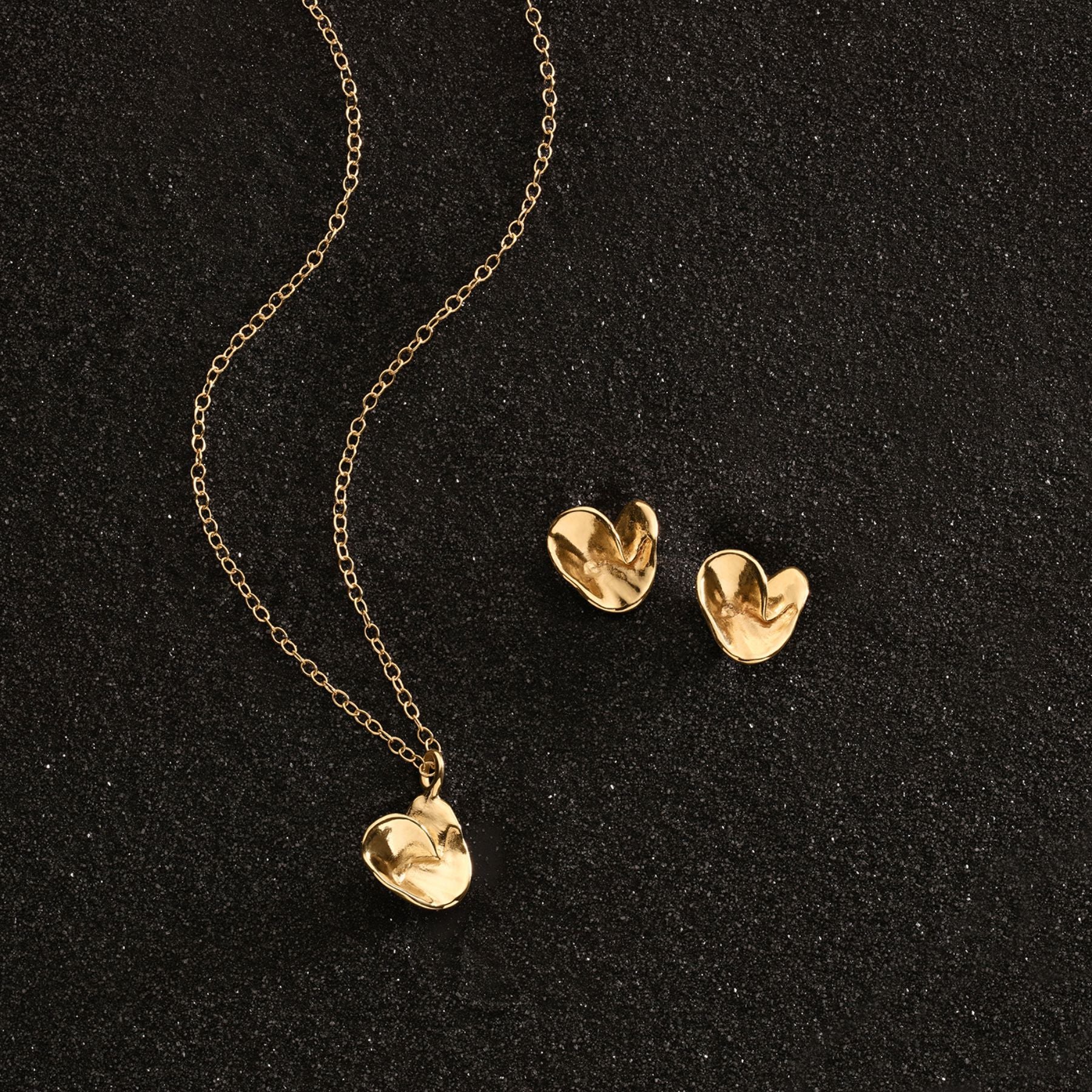 Sculptural heart pendant and stud earrings in 14k gold.