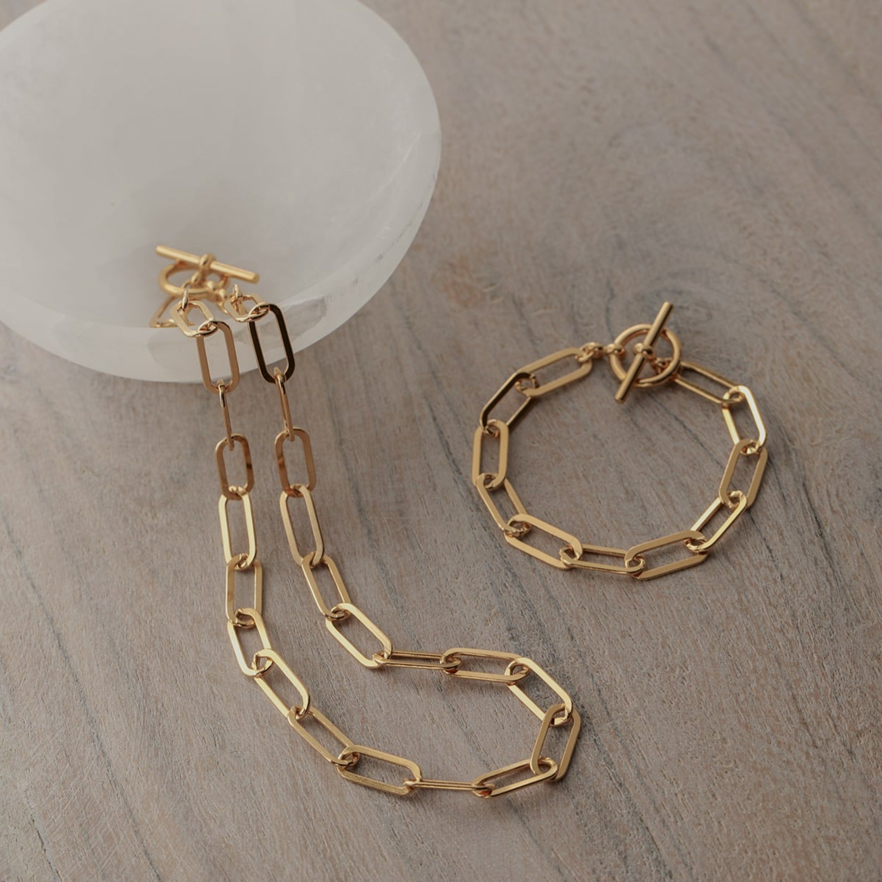 Elongated flattened paperclip chain bracelet with a toggle clasp in 18k gold vermeil.