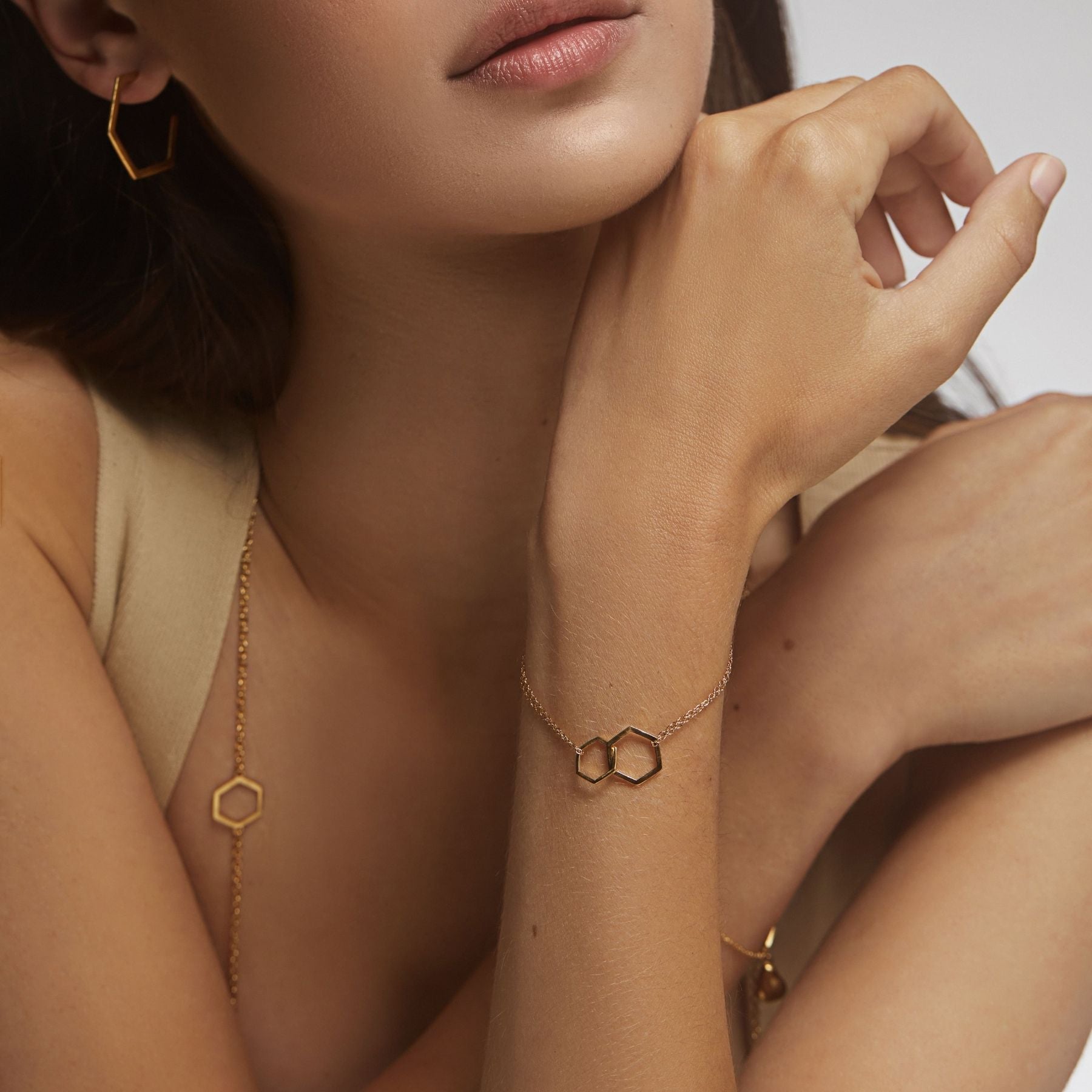 Geometric bracelet with  small and large hexagons interlocking with a delicate double chain with an Anjou pear charm in 18k vermeil gold.