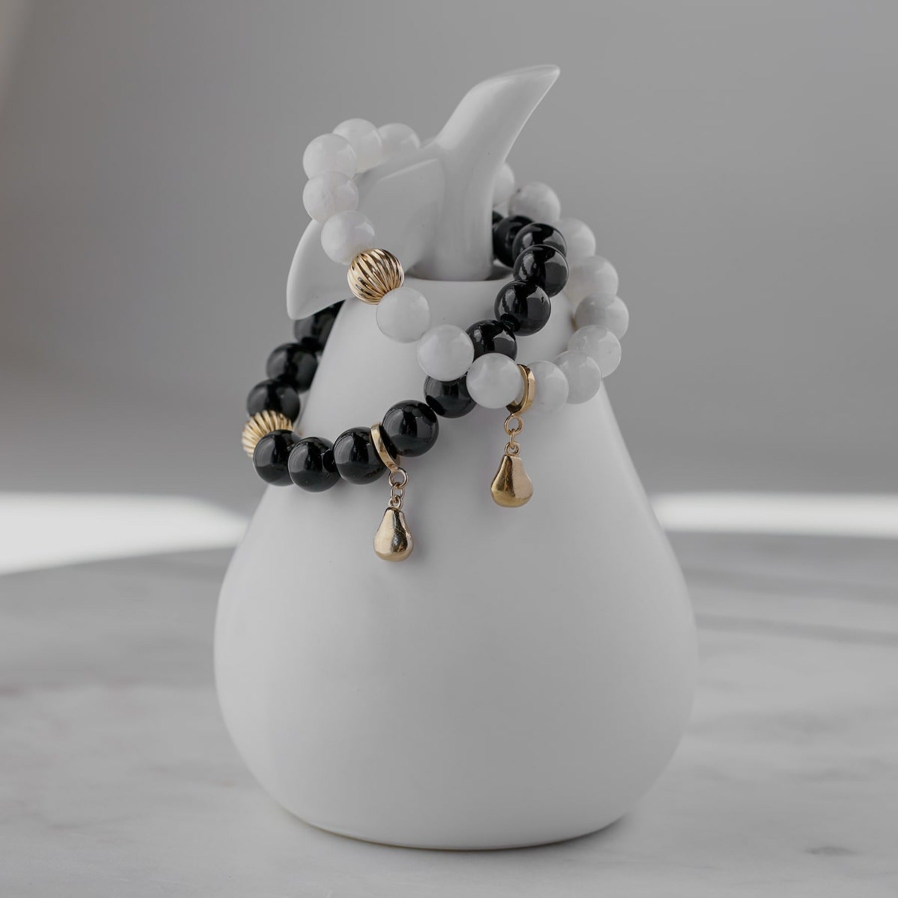 Black tourmaline crystal smooth gemstone elastic bracelet with 14k gold corrugated bead and pear charm.