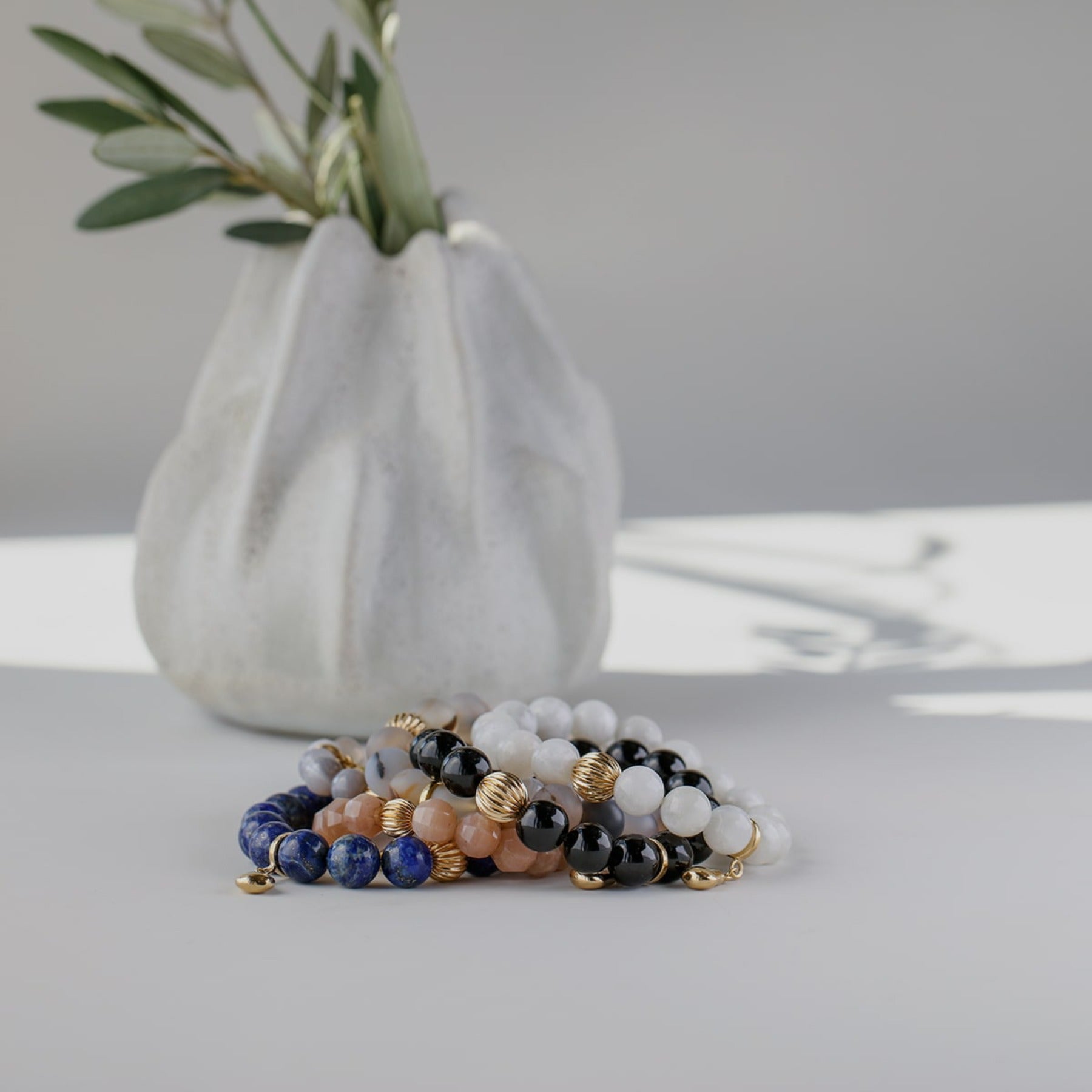 Black tourmaline crystal smooth gemstone elastic bracelet with 14k gold corrugated bead and pear charm.