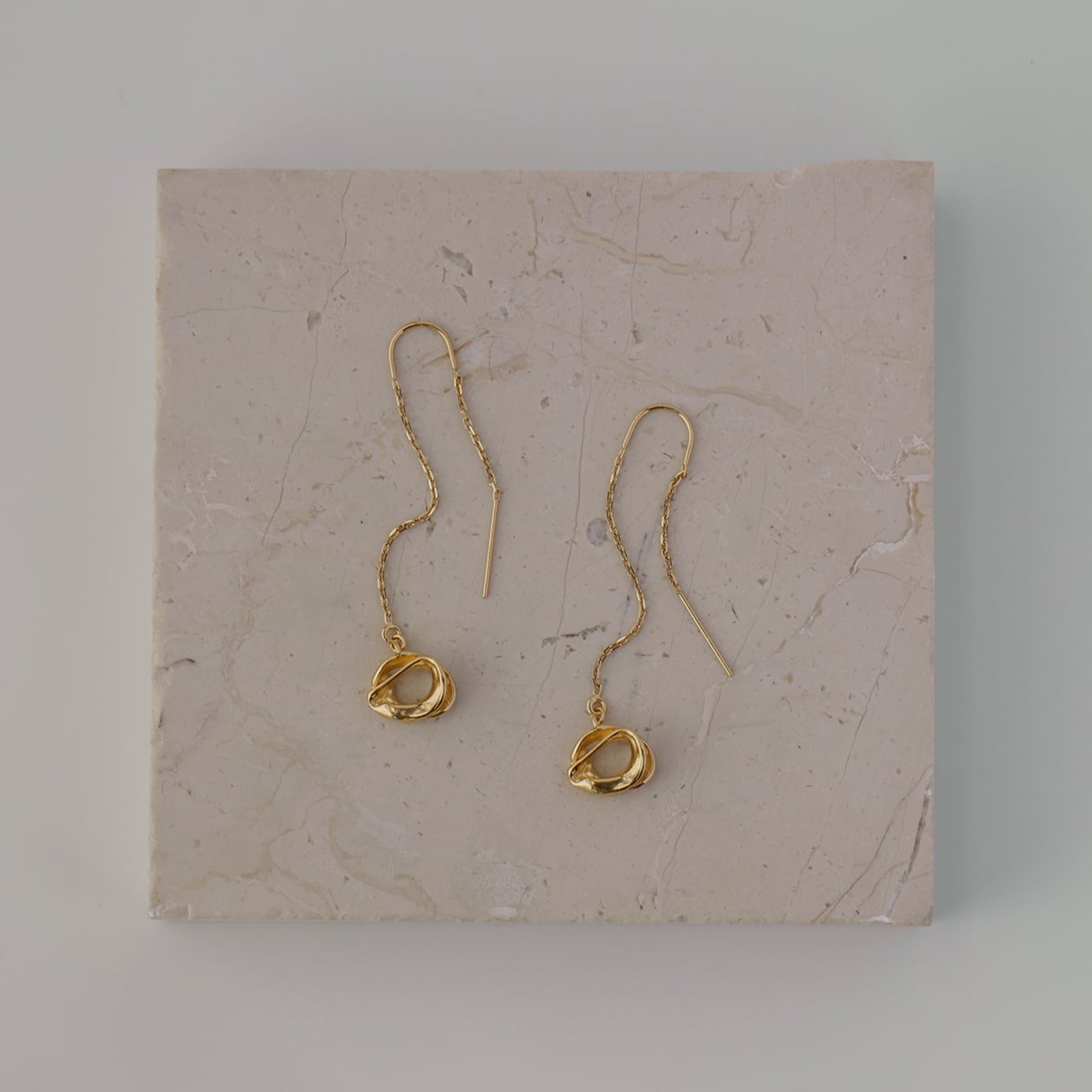 Abstract, circle dangling from a threader earring chain in 18k gold vermeil.